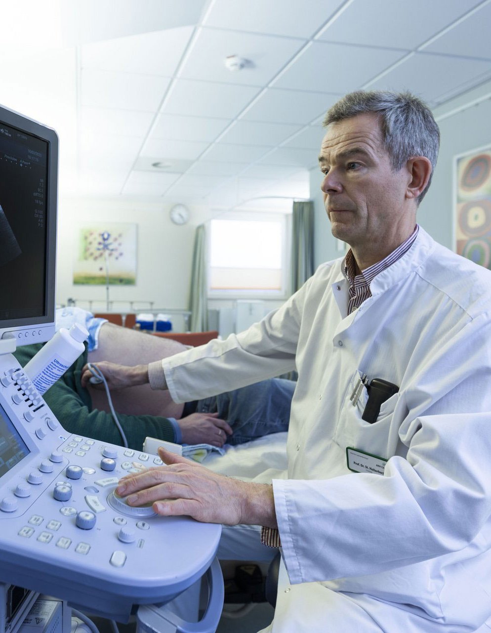 Ein Arzt macht einen Ultraschall an einem männlichen Patienten.