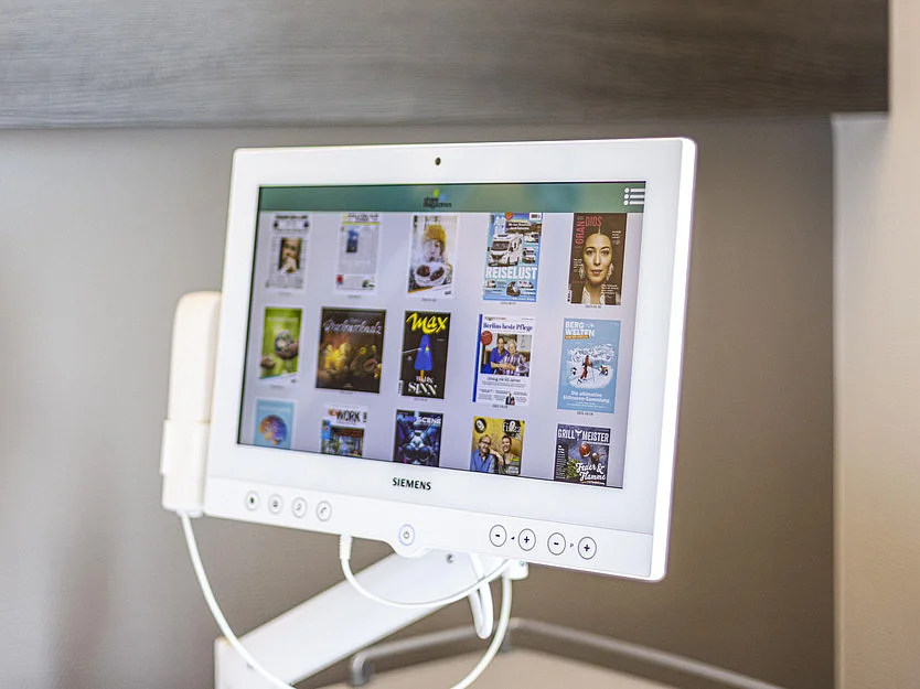 Flachbildschirm mit integriertem Entertainment-System am Patientenbett.
