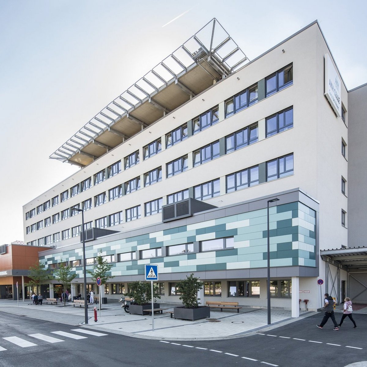 Moderne Krankenhausfassade des Allgemeinen Krankenhauses Celle mit Haupteingang und Fußgängerüberweg.