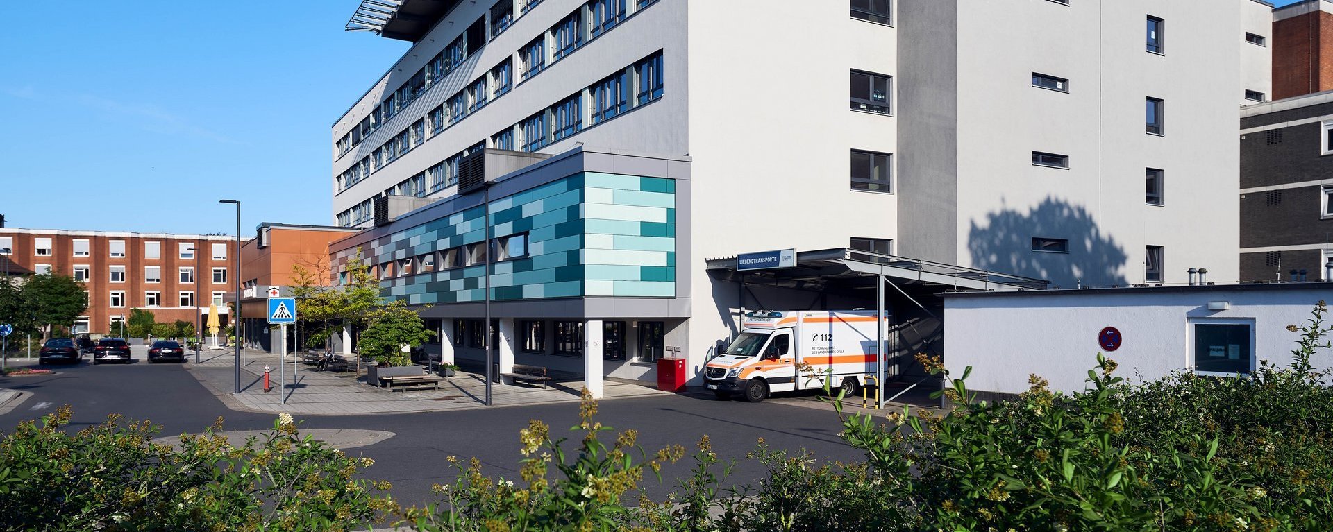 Außenansichten AKH Celle 2025 Moderne Krankenhausfassade des Allgemeinen Krankenhauses Celle mit Haupteingang und Fußgängerüberweg.