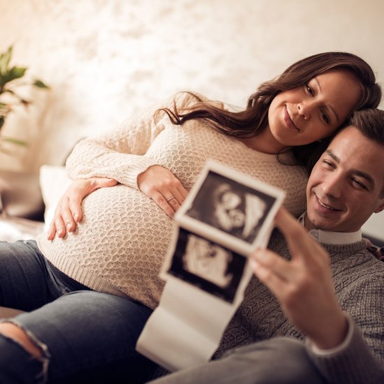 Beautiful young couple expecting baby Ein Paar erwartet ein Kind und zeigt Ultraschallbilder hoch.