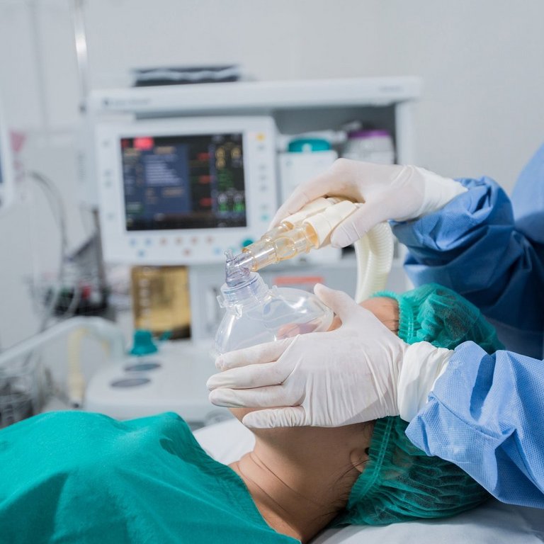 Anästhesist im OP des AKH Celle überwacht die Vitalfunktionen eines Patienten auf einem Monitor. Im Hintergrund ist medizinisches Equipment zu sehen.